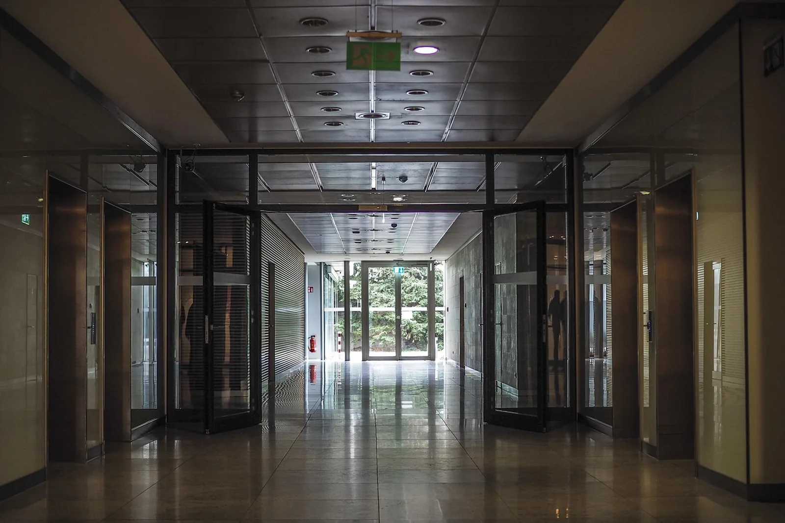 Quiet, empty office corridor with open glass doors before a meeting, a calm space for hypnosis for leadership