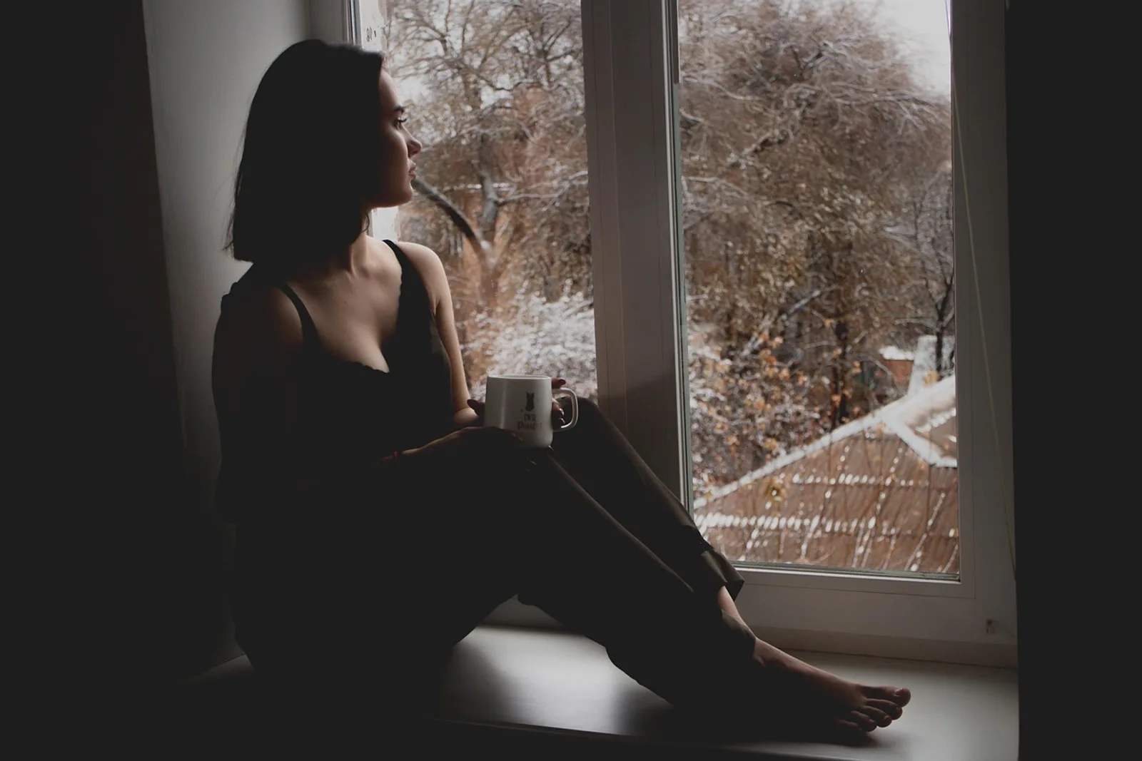 Woman in an armchair by the window, gaze lost in the light, showing what a trance state feels like while reading