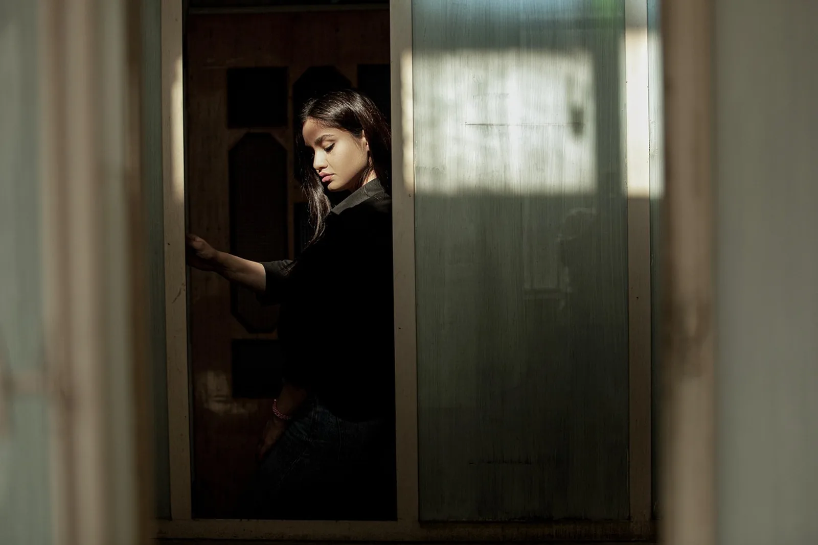 Woman pauses in a doorway in morning light: overcoming fear of rejection in relationships starts here