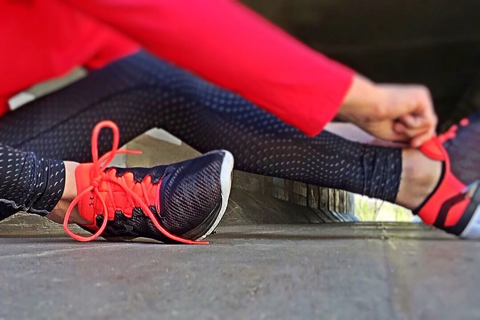 Frau schnürt morgens Laufschuhe im Flur – identitätsbasierte Gewohnheiten beginnen mit kleinen Handlungen