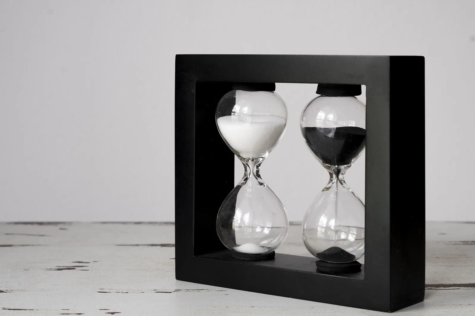 Two hourglasses on a calm table: the ten-minute start as a concrete step in how to stop procrastinating