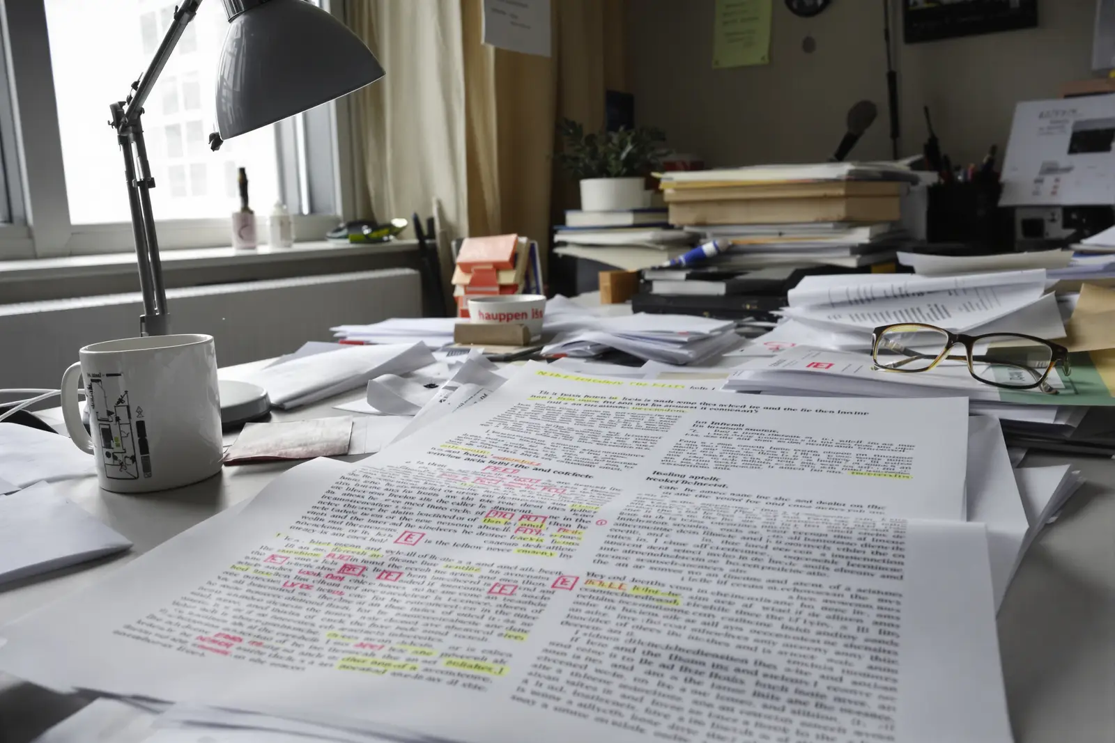 A stack of well-read scientific journals with reading glasses in the warm light of a desk lamp, the research behind Hypnotic Rise